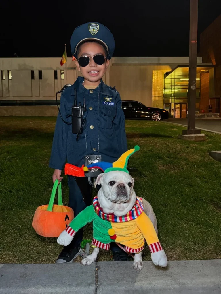 3. Police Officer Kid with Colorful Circus Clown Dog Costume on Halloween Night
