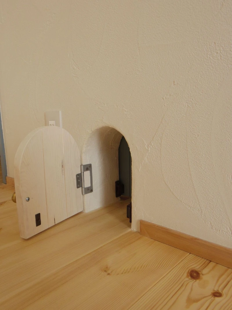 Arched Light Wood Plank Miniature Door Set in Textured Cream Plaster Wall