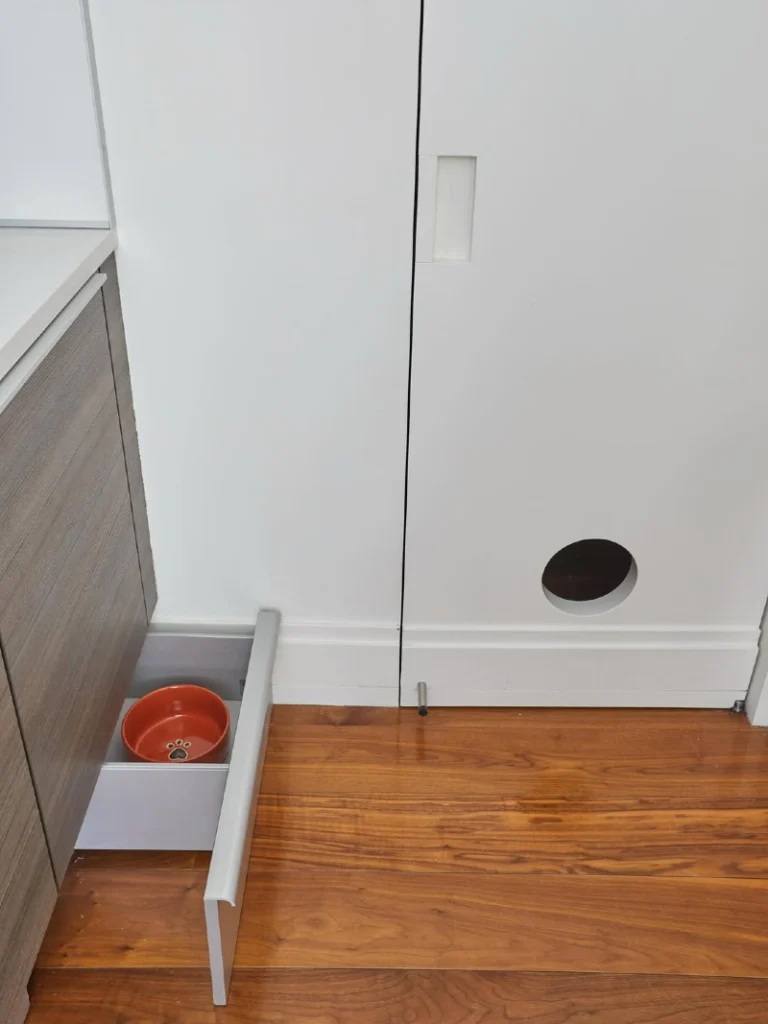 Circular Cutout in Flat-Panel White Cabinet Door with Pull-Out Pet Feeding Drawer