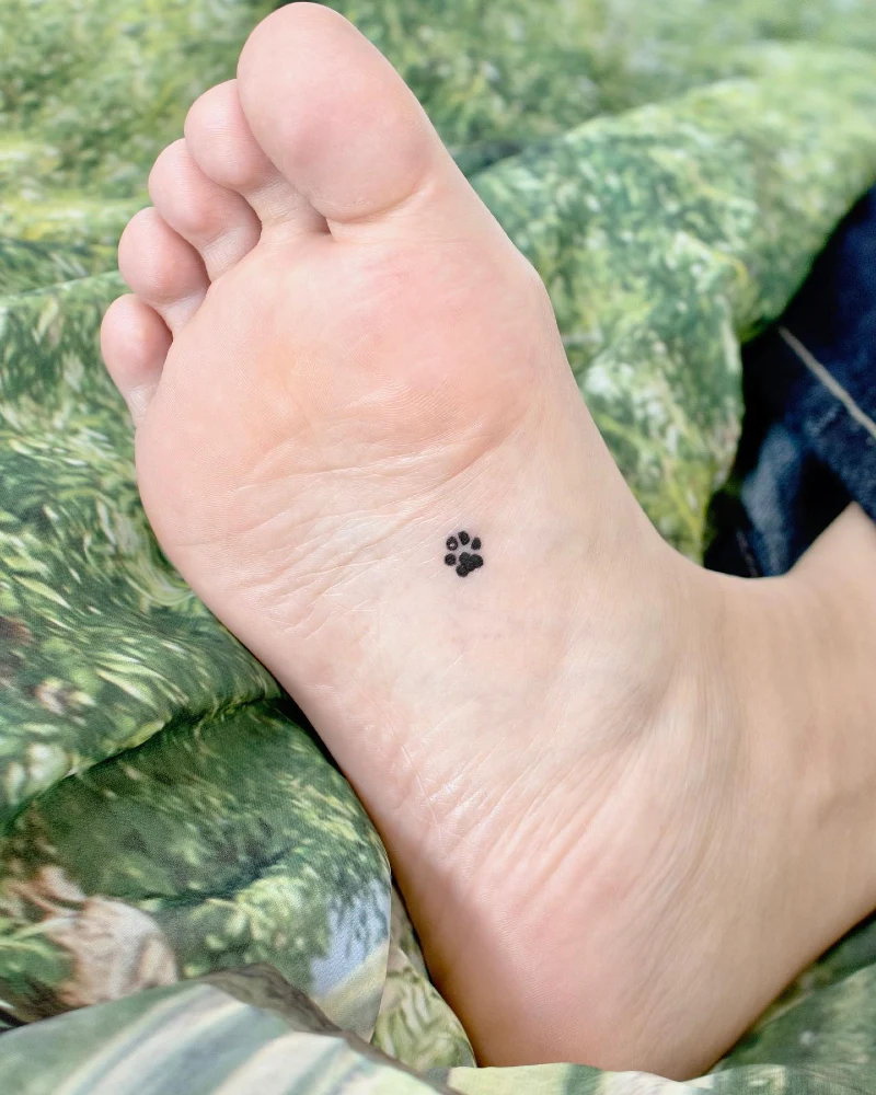 Micro Solid Black Paw Print Tattoo on the Sole of the Foot