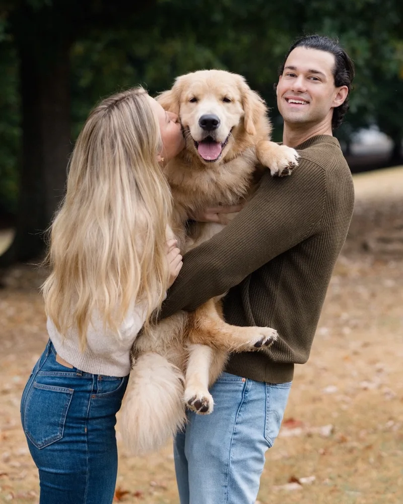 Olive Green and Cream Sweaters on a Couple Holding a Golden Retriever