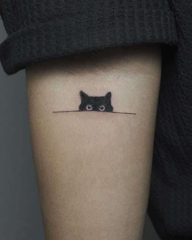 Peeking Black Cat Silhouette Tattoo on the Inner Arm