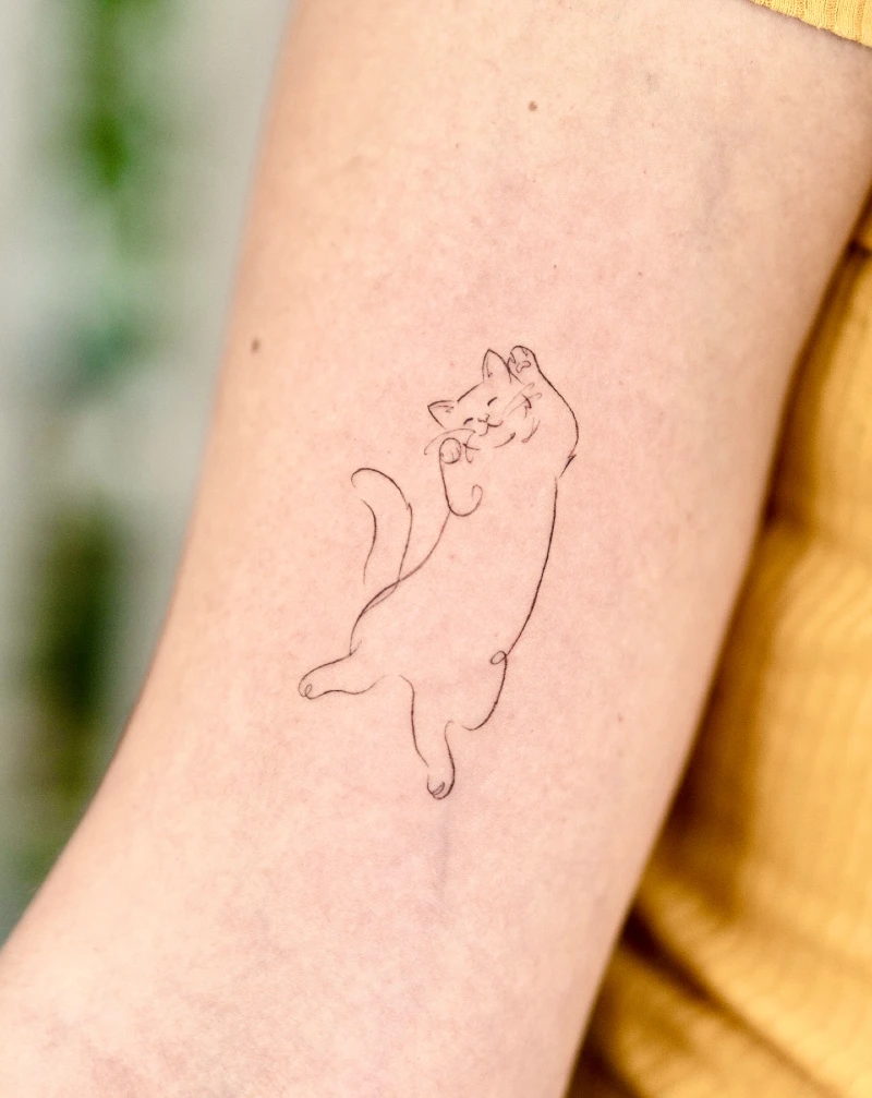 Playful Fine-Line Dancing Cat Tattoo on the Arm