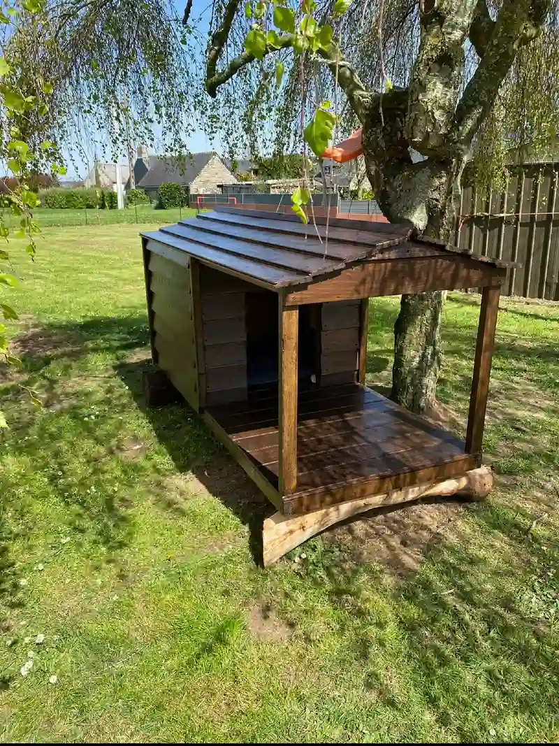 Rich Walnut Stained Kennel with Covered Veranda Raised on Natural Log Footers