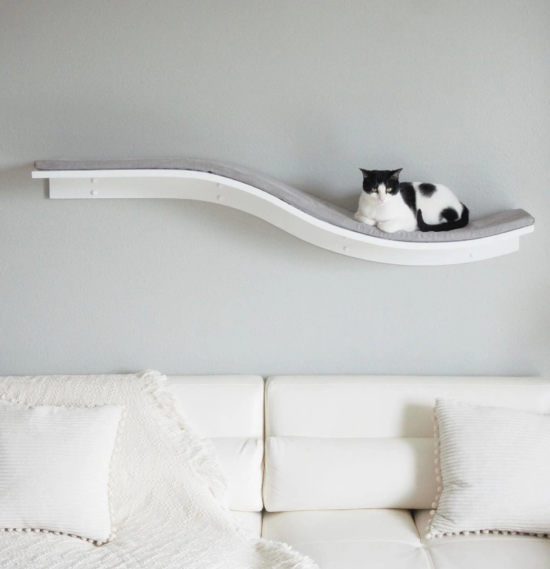 S-Shaped White Floating Cat Wave with Grey Fabric Cushion Above a Modern White Leather Sofa