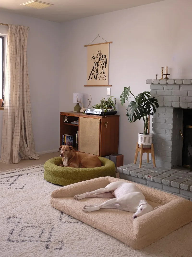 Textural BouclΓ© Loungers by a Painted Brick Fireplace