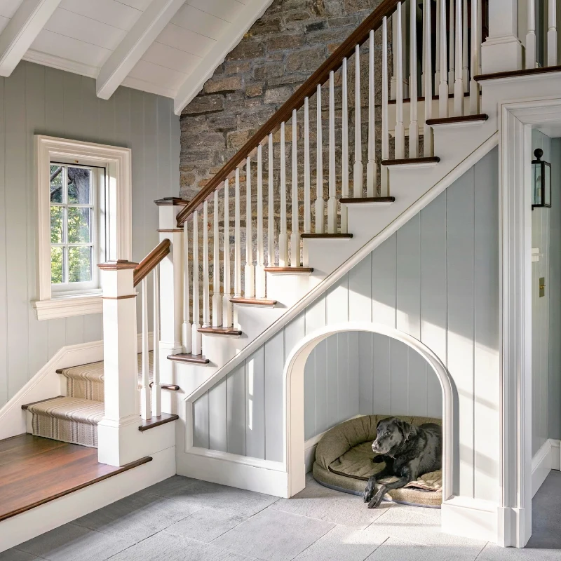 Arched Pale Blue Panelled Nook with Stone Accent Wall and Traditional White Spindle Balustrade
