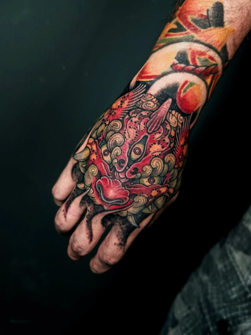 Crimson Foo Dog Hand Tattoo with Golden Mane