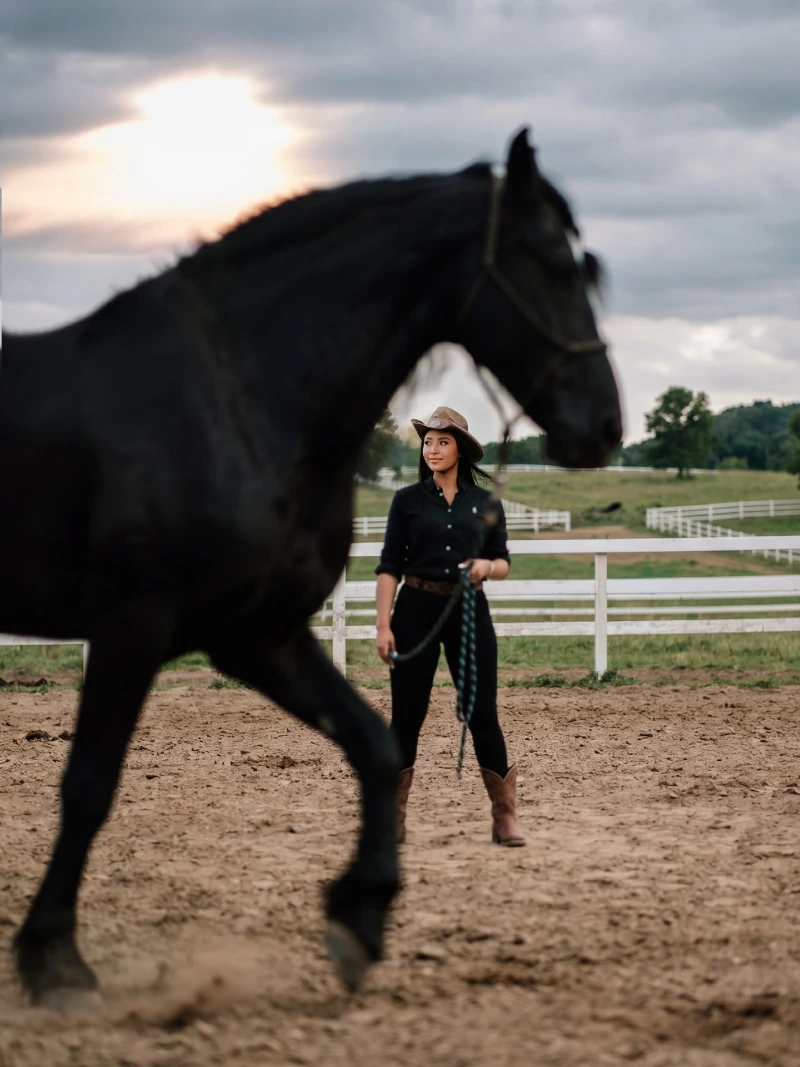Dark Western Wear and Cowboy Hat in a Dusty Arena