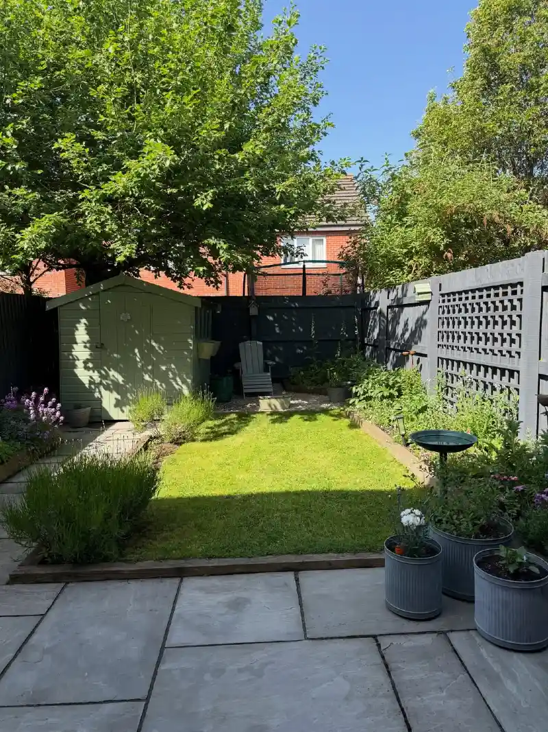 Flagstone Patio with Rectangular Lawn Nook, Sage Shed, and Corrugated Metal Planters