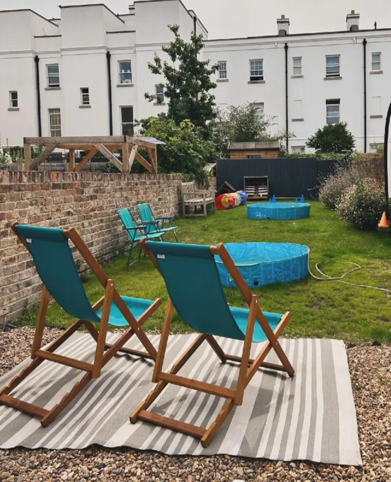 Grassy Lawn with Double Splash Pools and Striped Outdoor Rug on Gravel