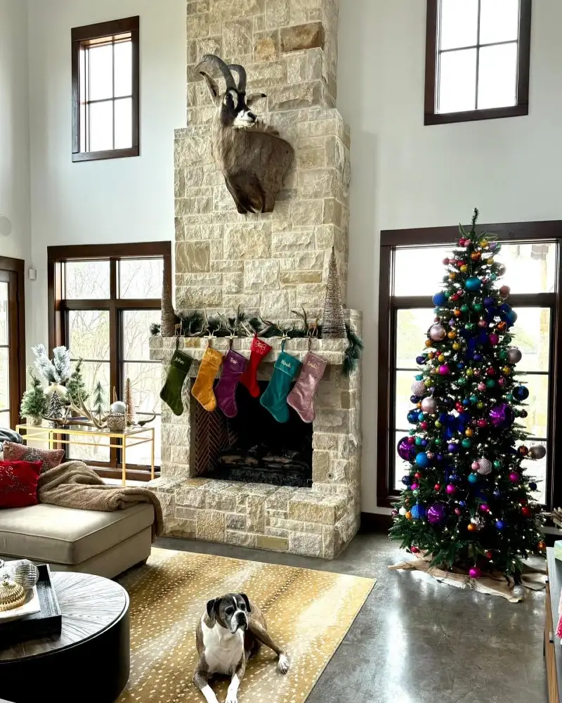 Great Room with Stone Fireplace, Jewel Toned Tree, and Fawn Patterned Rug