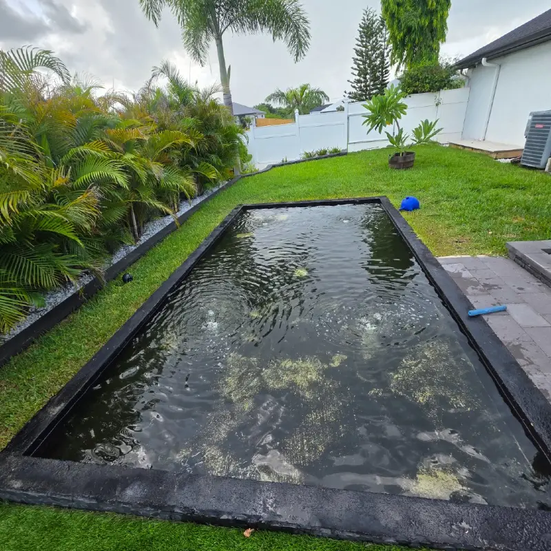 In-Ground Minimalist Water Feature with Dark Stone Border