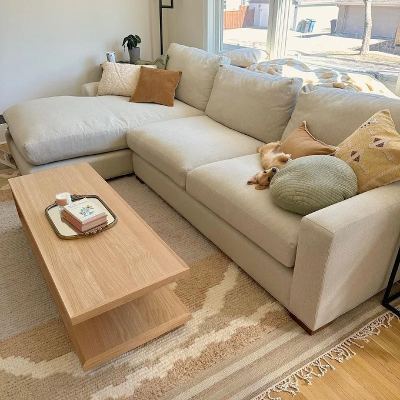 Light Beige Sectional with Layered Earth-Toned Pillows and Two-Tier Oak Coffee Table