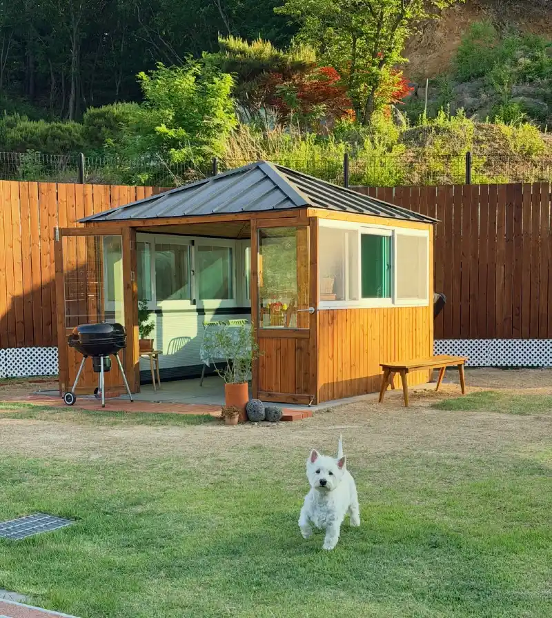 Modern Wooden Garden Pavilion with Charcoal Metal Roof and Open Green Lawn