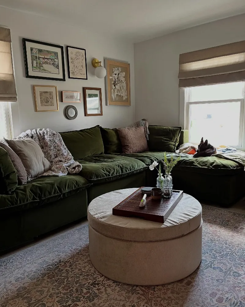 Olive Green Velvet Sectional with Vintage Floral Rug and Round Storage Ottoman