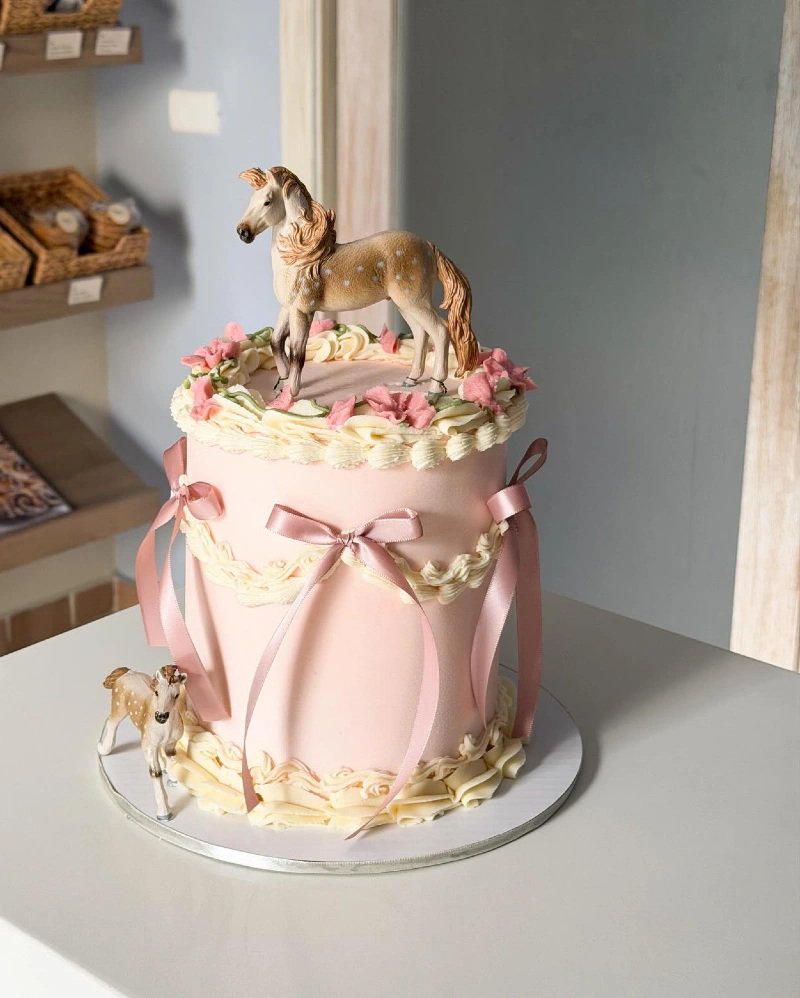 Pastel Pink Lambeth Cake with Satin Ribbons and Appaloosa Figurines