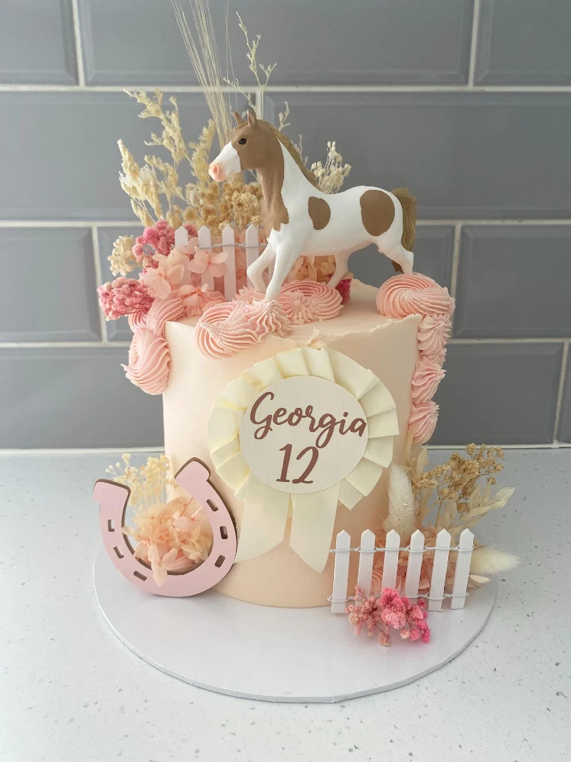 Peach-Blush Meadow Cake with Piped Rosettes, Miniature Fences, and Pinto Topper