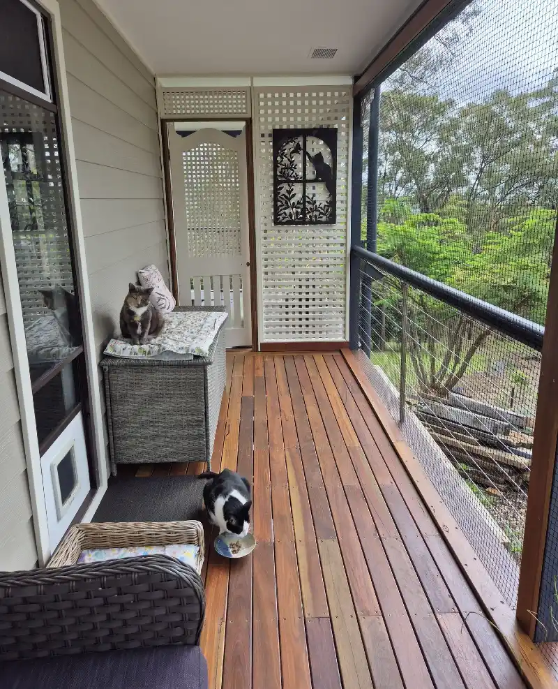 Polished Wood Plank Balcony with Woven Resin Storage Bench and Full-Height Netting Barrier