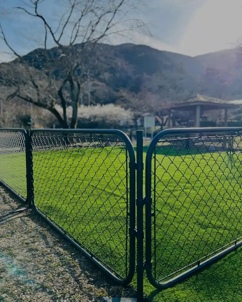 Rounded-Corner Black Chain-Link Panels over Synthetic Turf