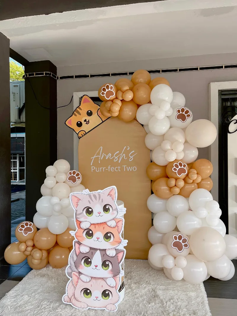 Tan Arched Backdrop with Asymmetric Neutral Balloon Garland and Stacked Cartoon Kitten Cutouts