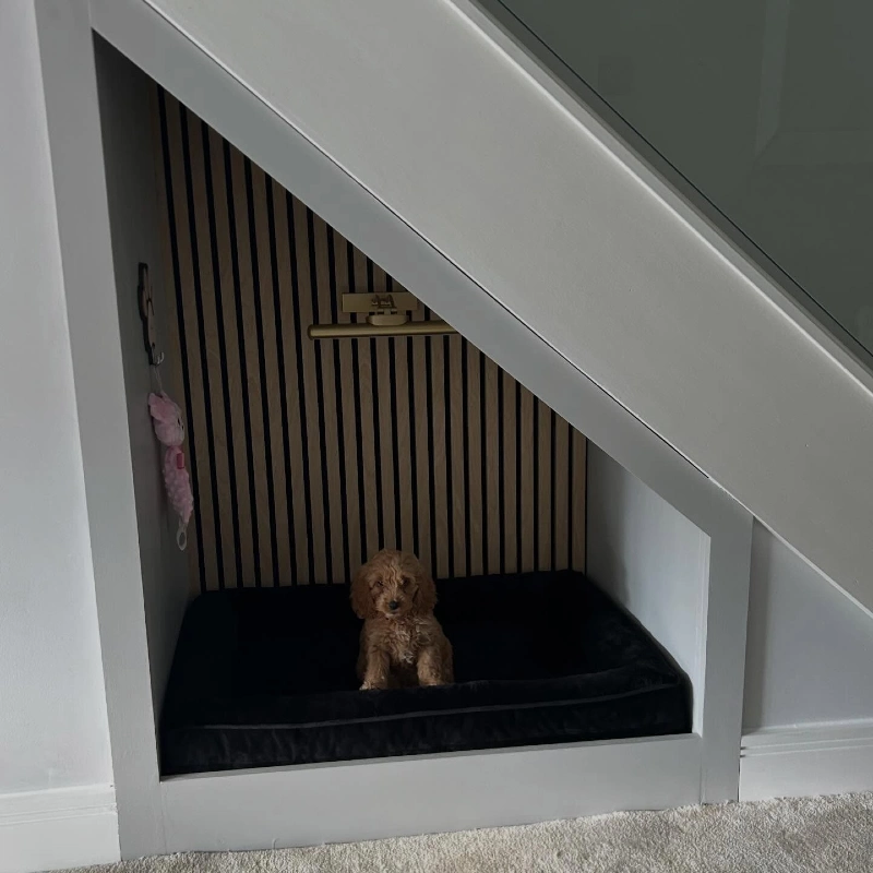 Vertical Oak Slat Alcove with Plush Black Bed and Brass Picture Light